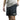 A person wearing a gray shirt and black athletic shorts with a logo on the side, reaching into a pocket.