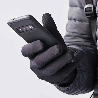 A hand modeling a glove, holding a phone to show the glove's touchscreen compatible fingertips. 