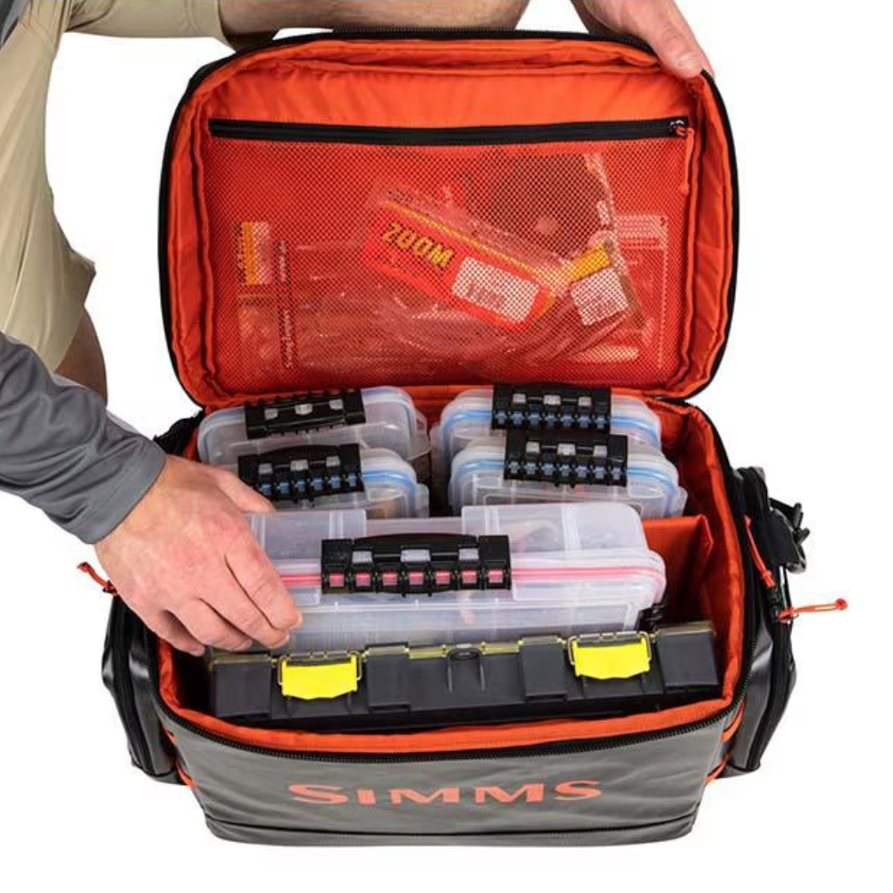 The inside of the bag, staged with six different tackle boxes inside of it and other fishing accessories in the zippered pocket under the lid. 