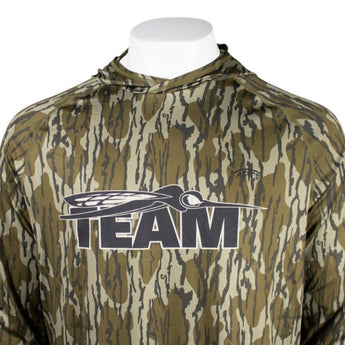 Close up of a camouflage hooded long sleeve with a black skeeter 'TEAM' logo on the chest.