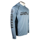 a blue performance hoodie with grey stitching and the 'Simms' and 'Skeeter' logos on the chest. The Yamaha logo is printed down the right sleeve.